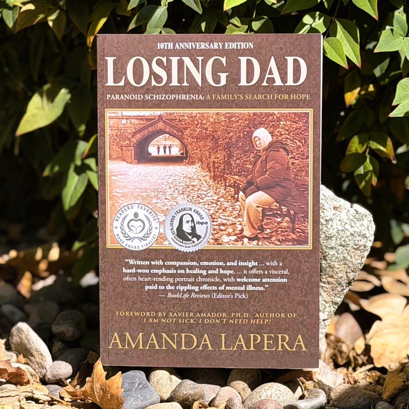 Losing Dad cover posed near rocks and bushes.